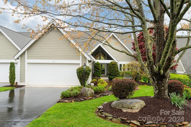 view of front of property featuring a garage and a front lawn