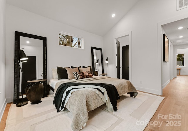 bedroom with light hardwood / wood-style floors and vaulted ceiling