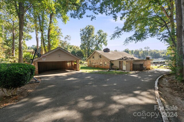 364 Catalina Dr, Mooresville, NC 28117 - view of front of house with a carport, a chimney, brick siding, and aphalt driveway