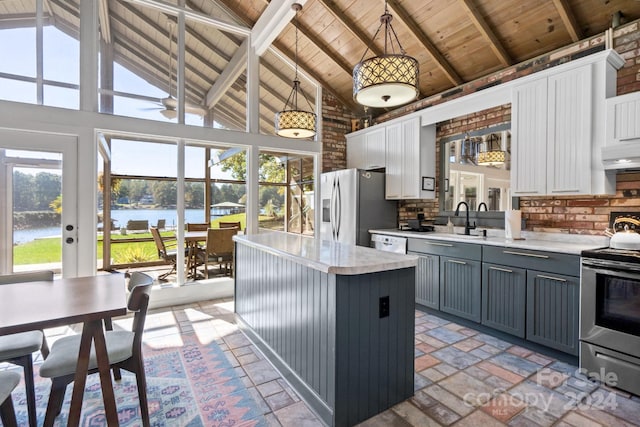 kitchen featuring appliances with stainless steel finishes, a healthy amount of sunlight, hanging light fixtures, and a water view