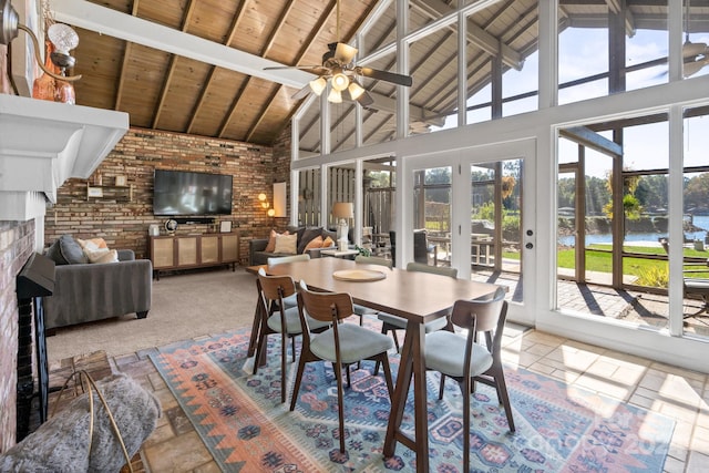 carpeted dining area featuring beamed ceiling, high vaulted ceiling, plenty of natural light, and ceiling fan