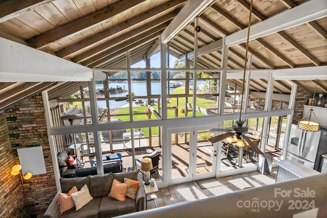 interior space featuring a wealth of natural light, beam ceiling, a water view, and ceiling fan