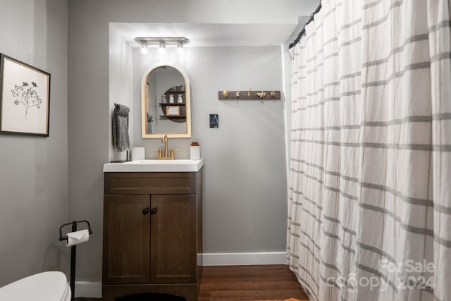 bathroom with vanity, toilet, hardwood / wood-style flooring, and walk in shower