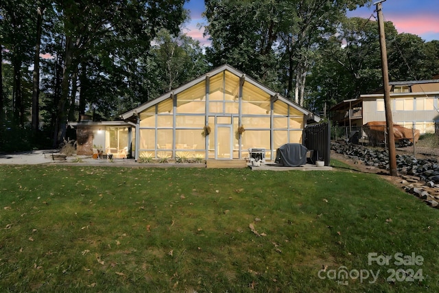 364 Catalina Dr, Mooresville, NC 28117 - back of property at dusk with a lawn, fence, a greenhouse, and an outdoor structure
