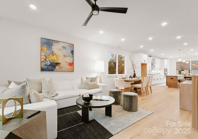 living room featuring light wood-type flooring and ceiling fan