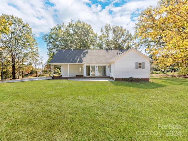 back of house featuring a yard and french doors