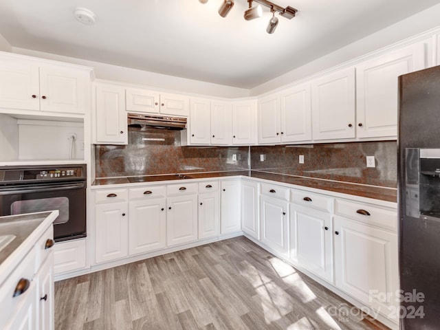 kitchen with tasteful backsplash, black appliances, light hardwood / wood-style flooring, and white cabinets