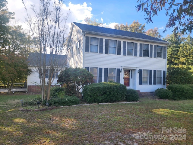 colonial-style house featuring a front yard