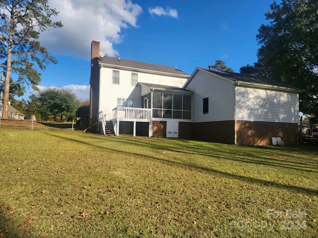 back of house featuring a sunroom and a lawn