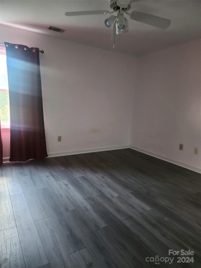 unfurnished room with dark wood-type flooring and ceiling fan