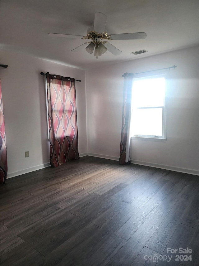 empty room with dark wood-type flooring and ceiling fan