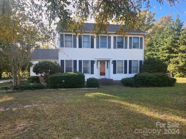 colonial house featuring a front lawn