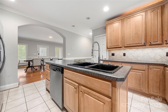 kitchen featuring sink, light tile patterned floors, dishwasher, backsplash, and an island with sink