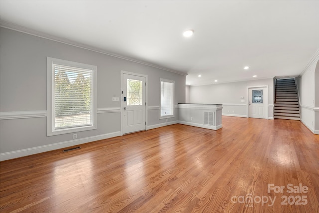 unfurnished living room featuring crown molding and light hardwood / wood-style floors