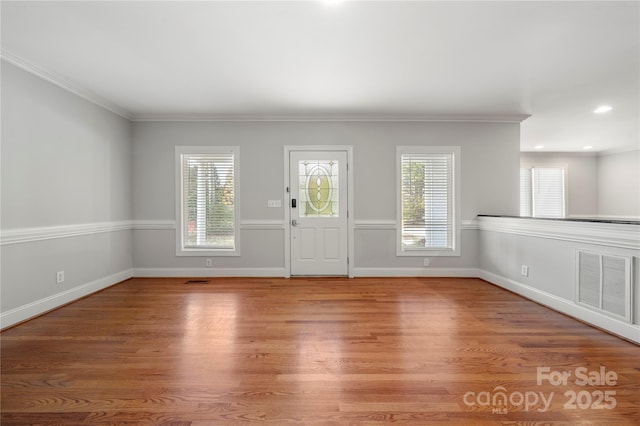 entryway featuring crown molding and light wood-type flooring