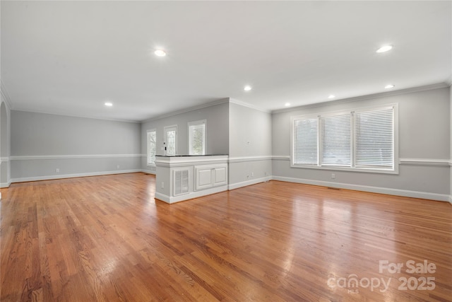 unfurnished living room with ornamental molding and light wood-type flooring