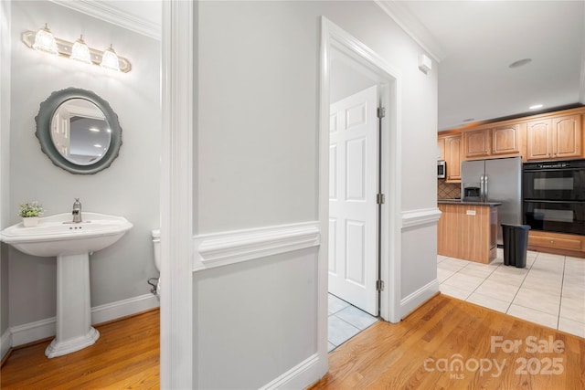 kitchen with backsplash, stainless steel appliances, crown molding, and light tile patterned floors