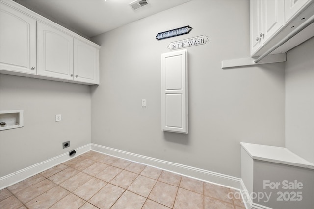 laundry area with cabinets, electric dryer hookup, washer hookup, and light tile patterned floors