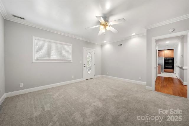 carpeted spare room featuring ornamental molding and ceiling fan