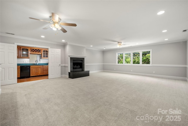 unfurnished living room with ceiling fan, light colored carpet, crown molding, and indoor wet bar