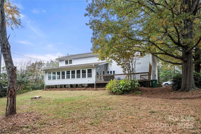 back of property with a yard and a deck