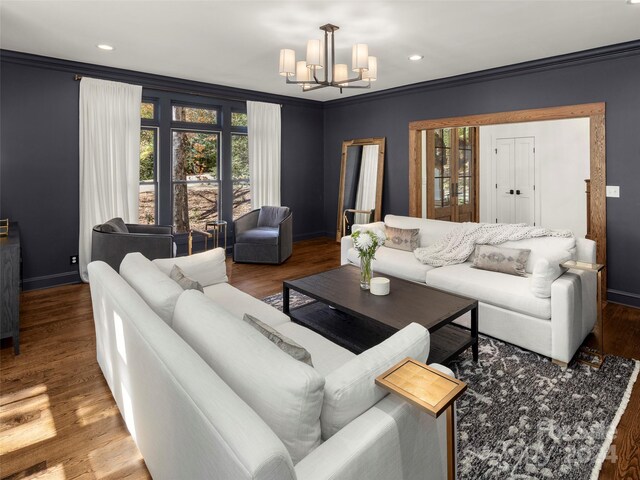 living room with crown molding, wood-type flooring, and a chandelier