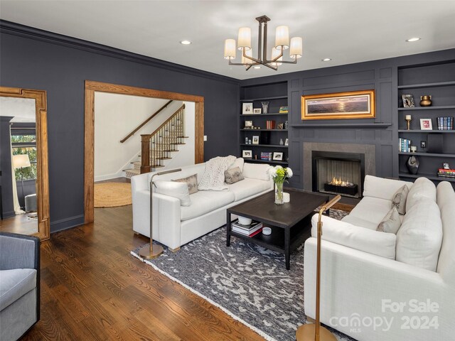 living room with crown molding, a notable chandelier, built in features, and dark hardwood / wood-style flooring