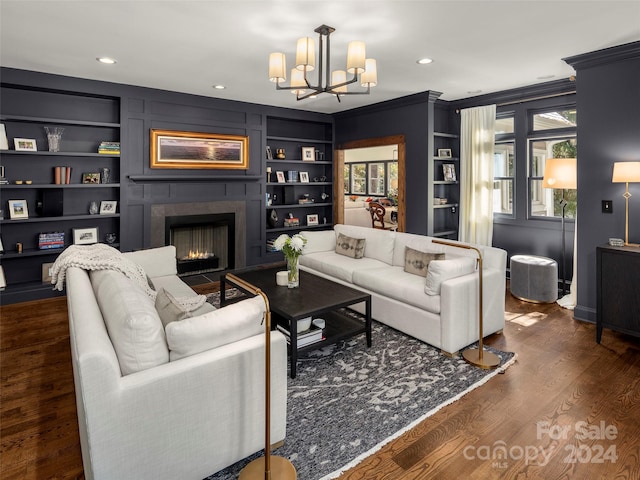 living room featuring ornamental molding, a chandelier, dark wood-type flooring, and built in shelves