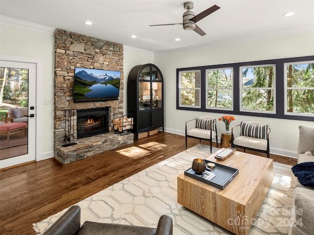 living room featuring ornamental molding, hardwood / wood-style flooring, a fireplace, and ceiling fan