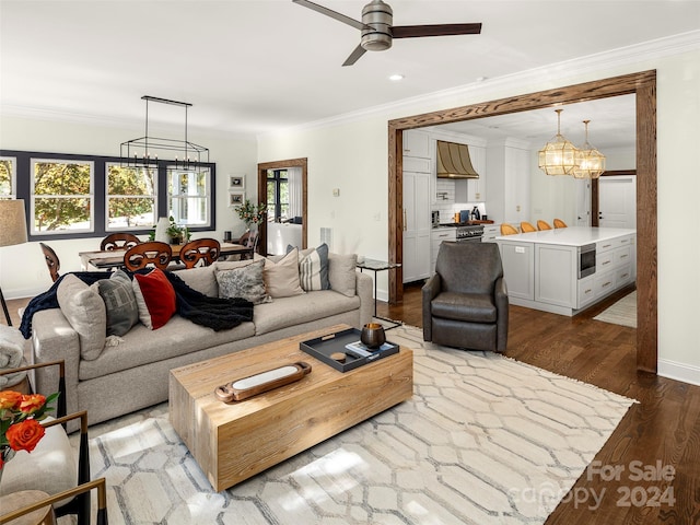 living room with crown molding, wood-type flooring, and a wealth of natural light