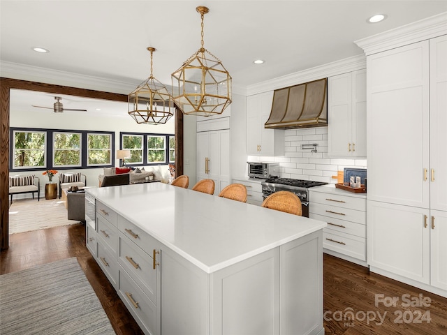 kitchen featuring dark hardwood / wood-style flooring, a kitchen island, white cabinetry, custom range hood, and high end range