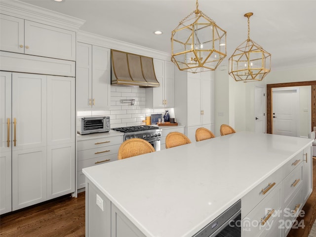 kitchen featuring a center island, pendant lighting, stainless steel stove, premium range hood, and dark hardwood / wood-style floors