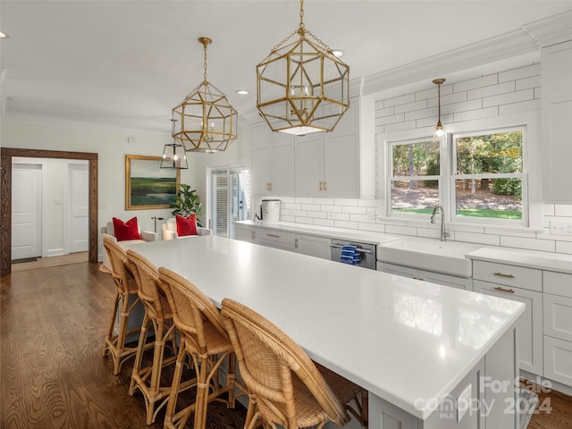 kitchen featuring sink, a breakfast bar, a center island, and hanging light fixtures