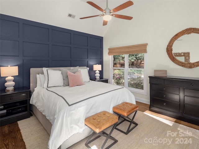 bedroom featuring light hardwood / wood-style floors, lofted ceiling, and ceiling fan