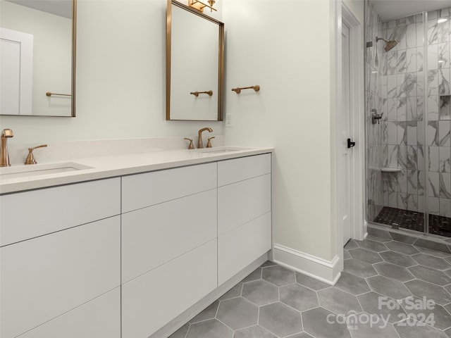 bathroom with vanity, a tile shower, and tile patterned flooring