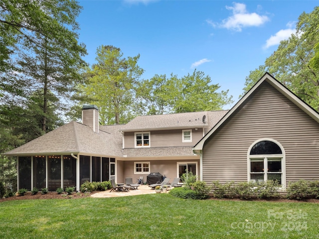 back of property featuring a yard, a patio, and a sunroom