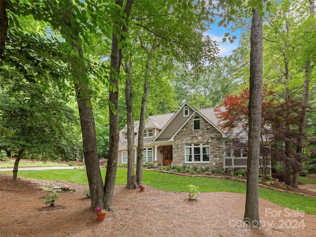 craftsman inspired home featuring a garage and a front lawn