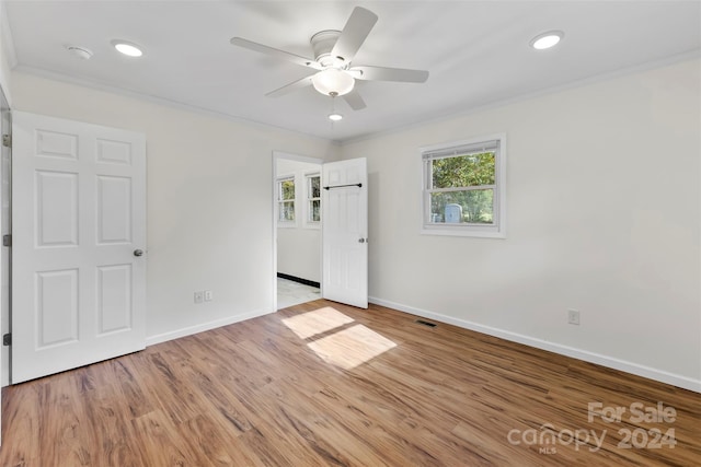 unfurnished room with crown molding, light wood-type flooring, and ceiling fan