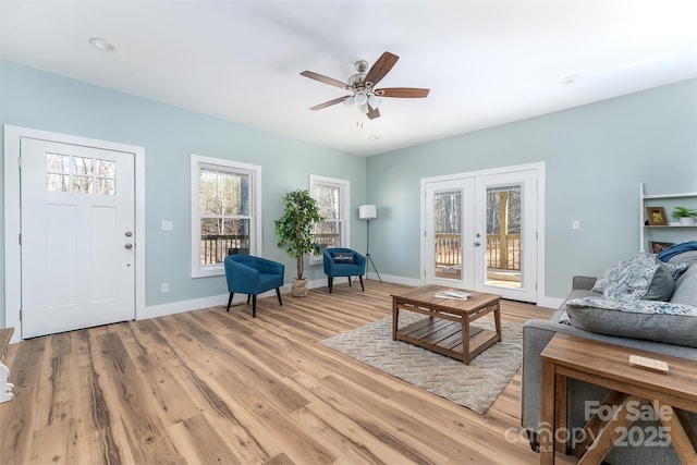 living area with french doors, baseboards, ceiling fan, and light wood finished floors