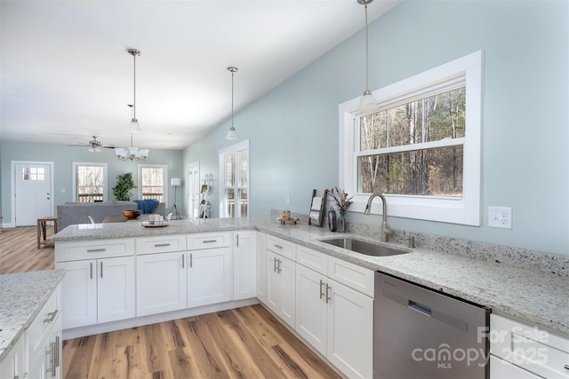 kitchen featuring light wood-style flooring, a peninsula, a sink, white cabinets, and dishwasher