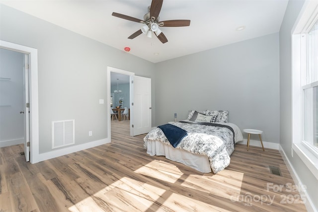 bedroom featuring wood finished floors, visible vents, and baseboards