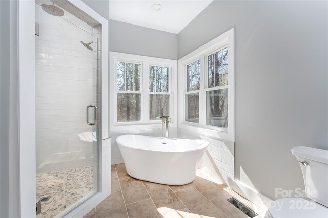 full bath with a stall shower, visible vents, toilet, tile patterned flooring, and a freestanding tub