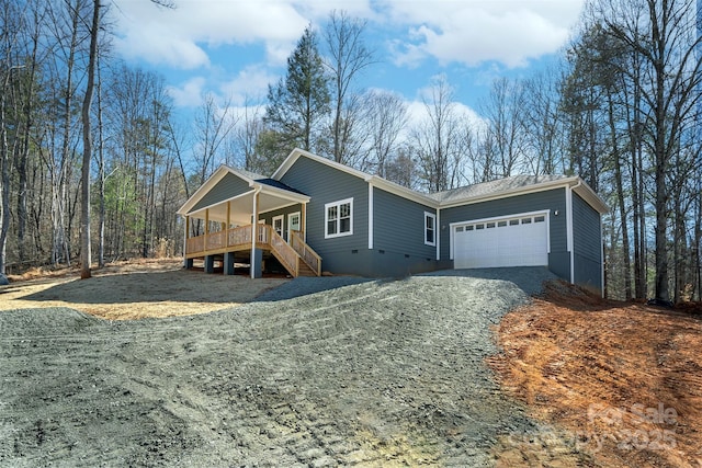 single story home with a garage, covered porch, stairs, crawl space, and gravel driveway