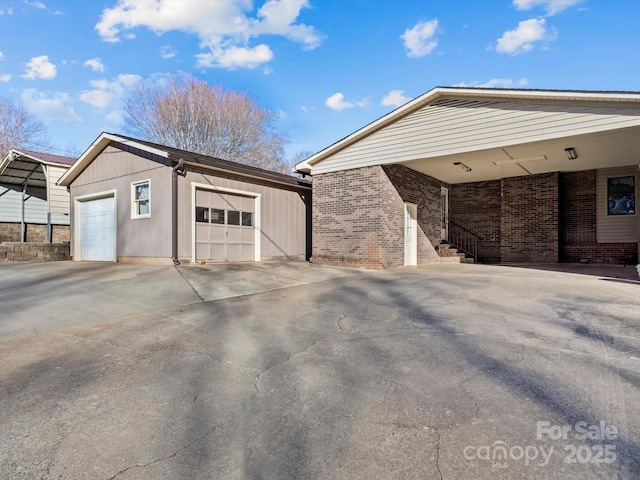 view of side of home with a garage, an outdoor structure, and a carport