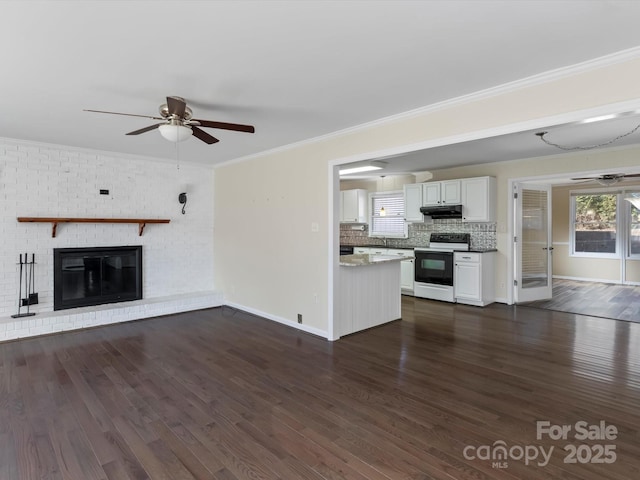 unfurnished living room with crown molding, ceiling fan, dark hardwood / wood-style flooring, and a brick fireplace