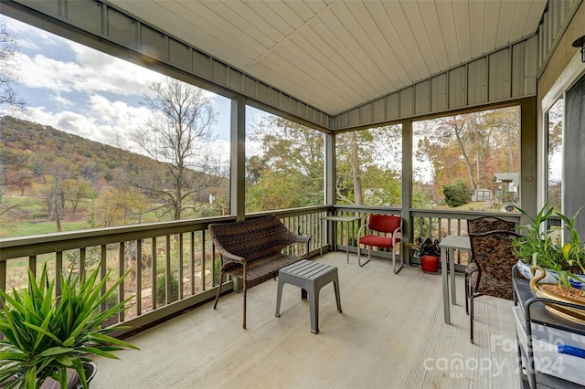 sunroom / solarium featuring a mountain view and wood ceiling