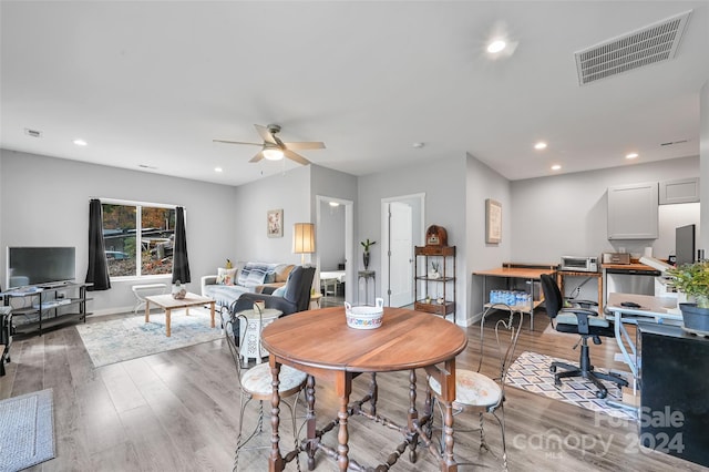 dining area with hardwood / wood-style flooring and ceiling fan