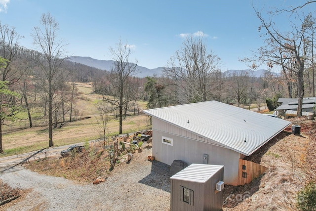 view of property exterior with a mountain view and metal roof