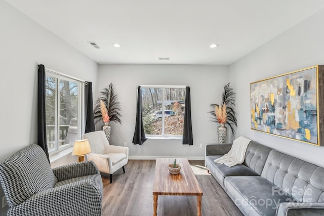 living area featuring baseboards, visible vents, wood finished floors, and recessed lighting