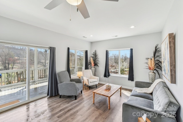 living area with recessed lighting, wood finished floors, a ceiling fan, and baseboards